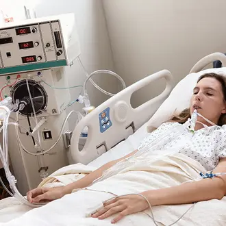 A ventilated patient resting in a hospital bed